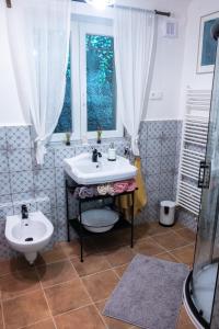 un bagno con lavandino, water e finestra di Chaloupka pod skalou a Libošovice
