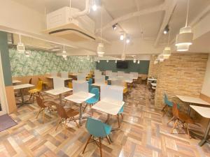 uma sala de aula com mesas e cadeiras e uma parede de tijolos em Hotel Kansai em Osaka
