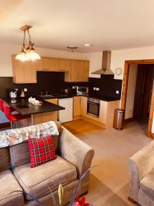 a living room with a couch and a kitchen at Red Stag Apartment in Nairn