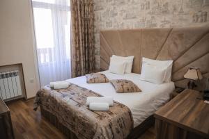 a bedroom with a large bed with two pillows on it at Jermuk Moscow Health Resort in Jermuk