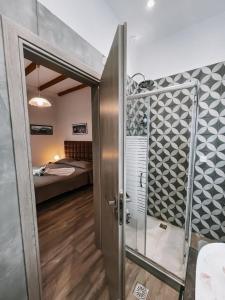 a bathroom with a shower and a door to a bedroom at Galini Studios Paralia Platanou in Akrata