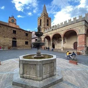 a fountain in the middle of a courtyard with a building at Il Cortiletto in Castelbuono