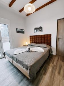 a bedroom with a large bed and a large window at Galini Studios Paralia Platanou in Akrata