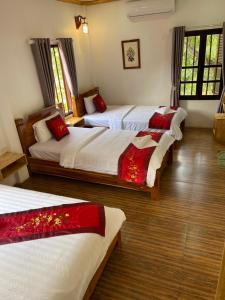 1 dormitorio con 3 camas con sábanas rojas y blancas en Liberty Place, en Luang Prabang