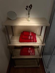 a shelf with two red pillows and a mirror at Red Stag Apartment in Nairn