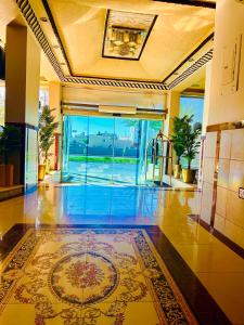 a lobby with a tile floor and a glass door at Arabian Palm Hotel in Rabigh