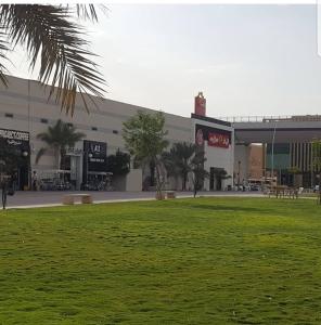 un gran edificio con un parque enfrente en فيولا للشقق المخدومة, en Riad