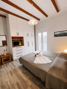 a bedroom with a large bed and a microwave at Galini Studios Paralia Platanou in Akrata