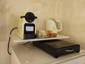 a shelf with a coffee maker and a toaster on it at CASA CHIOMEI 