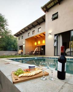 a bottle of wine and wine glasses next to a pool at Hyena Den - Marloth Park in Marloth Park