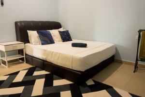 a bed in a bedroom with a black headboard at 2 Storey Semi-D Homestay Nilai and KLIA, F1 Sepang with Pool in Nilai