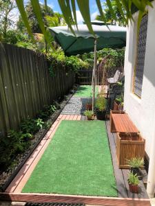 a backyard with a green lawn and a fence at Suva City Accommodation in Suva
