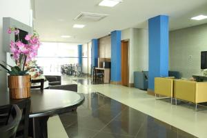 a lobby with a table and chairs and a room at Hit Hotel in Salvador