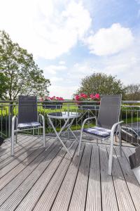 2 Stühle und ein Tisch auf einer Terrasse in der Unterkunft Hotel-Pension Marlies in Neuharlingersiel