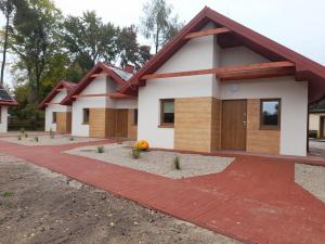 ein Haus mit einer roten Backsteineinfahrt in der Unterkunft Miejsko Gminny Ośrodek Sportu i Rekreacji in Łopuszno