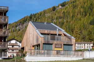 a large wooden building in front of a mountain at Montela Hotel & Resort - Montela Pavillon in Saas-Grund
