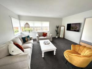 a living room with two couches and a coffee table at Bright & Central Home in Auckland