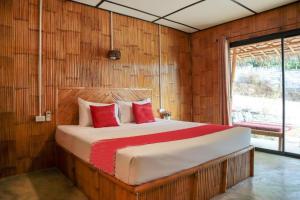 a bedroom with a large bed with red pillows at Chom Dao Resort in Ko Lanta