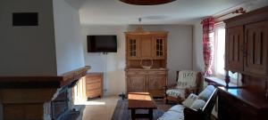 een woonkamer met een tv en een bank en een televisie bij Bellavie2 in La Bresse