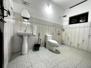 Kovalam Beach House في تريفاندروم: حمام مع مرحاض ومغسلة ومرآة