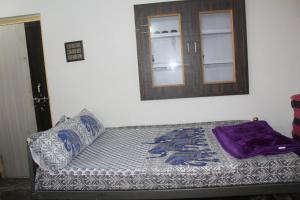a bed in a room with a window and a mirror at pavan's villa in Hampi