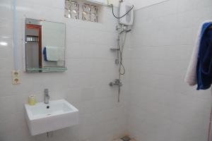 uma casa de banho branca com um lavatório e um espelho em Sunil Lanka Hotel em Aluthgama