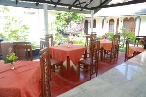 um restaurante com mesas e cadeiras com toalha de mesa vermelha em Sunil Lanka Hotel em Aluthgama