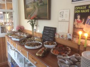 un buffet con diferentes tipos de comida en una mesa en Postholderens sted en Guldborg