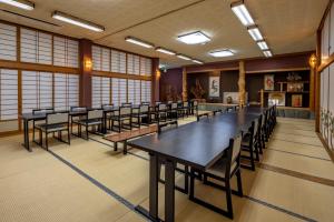 una fila de mesas y sillas en una habitación con ventanas en Sawaki en Imabari