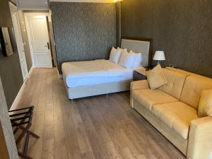 pokój hotelowy z łóżkiem i kanapą w obiekcie Mell Hotel w mieście Trabzon