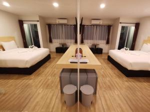 a hotel room with two beds and a table at The charlotte smart hotel lopburi in Lop Buri