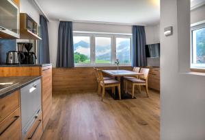 Appartementhaus Madlen في هينترستودر: مطبخ وغرفة طعام مع طاولة وكراسي