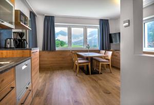 a kitchen and dining room with a table and chairs at Appartementhaus Madlen in Hinterstoder