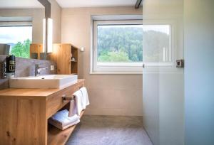 ein Bad mit einem Waschbecken und einem Fenster in der Unterkunft Appartementhaus Madlen in Hinterstoder