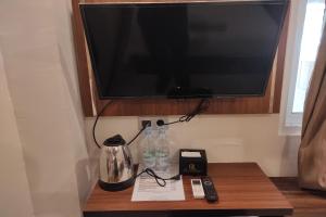 TV sobre una mesa de madera en OYO 92089 Hotel Subur, 