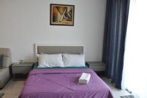 a bedroom with a bed with a purple blanket at Bayu Bangi in Bangi