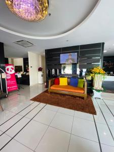 a living room with a couch on a rug at Just Hotel BP in Batu Pahat