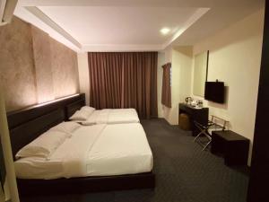 a hotel room with a bed and a desk at Just Hotel BP in Batu Pahat