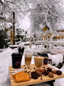 a table with cookies and two cups of coffee and drinks at Qafqaz Fountain cottage in Gabala