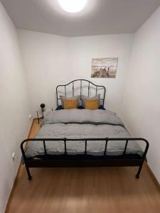 ein Schlafzimmer mit einem Bett in einem weißen Zimmer in der Unterkunft R&L Apartment Uhlandstrasse in Leipzig