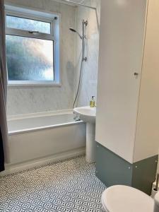a bathroom with a sink and a tub and a toilet at Gorgeous spacious 2 bedroom apartment in Gateshead