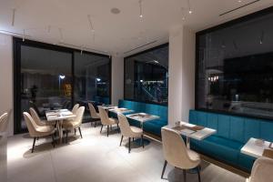 un restaurante con mesas, sillas y ventanas grandes en Hotel Dei Nani, en Iesi