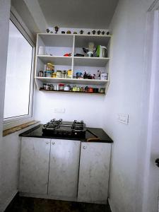 a small kitchen with a stove and a window at RVR Home - Beautiful Rooms in Bangalore