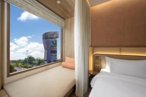 a bedroom with a bed and a window with a view at Centara Ubon in Ubon Ratchathani