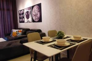 una sala de estar con una mesa y un sofá en Cozy Spacious Home 2 BR SKS Habitat Larkin JB, en Johor Bahru