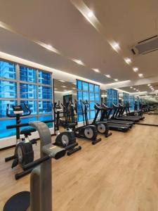 un gimnasio con una fila de pisadas y máquinas en Cozy Spacious Home 2 BR SKS Habitat Larkin JB, en Johor Bahru