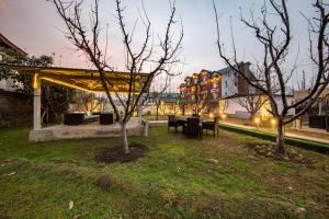 um parque com duas árvores e bancos e um edifício em Apple Orchard Resort & Spa em Srinagar