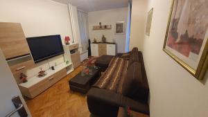 a living room with a couch and a flat screen tv at Apartman Jogi in Vračar (historical)