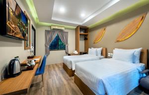 a hotel room with two beds and a television at At Rice Resort in Nakhon Nayok