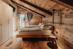 um quarto com uma cama e uma parede de madeira em Chalet Tannalm em Bad Kleinkirchheim